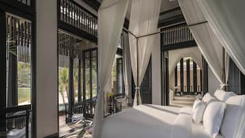 Un dormitorio con cama con dosel, ventanas amplias y vista a la playa.