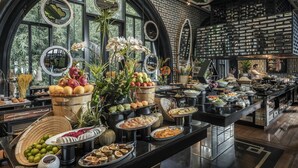 Un buffet con una varietà di cibi, tra cui frutta, verdura e dolci, disposti su un lungo tavolo.