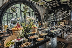 A buffet with a variety of food items, including fruits, vegetables, and desserts, arranged on a long table. - InterContinental Danang Sun Peninsula Resort by IHG (Da Nang)