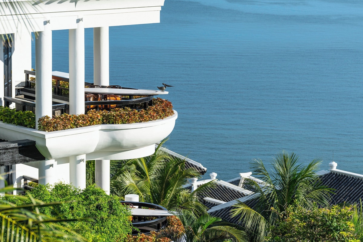 A modern building with a balcony overlooking a body of water.