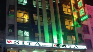A hotel with a prominent 'SITA' sign, featuring a modern architectural design with illuminated green and red lights. - Hotel Sita International (New Delhi)