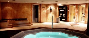 A spa area with a hot tub, seating, and a towel rack. - Europa Annex (Saas-Fee)