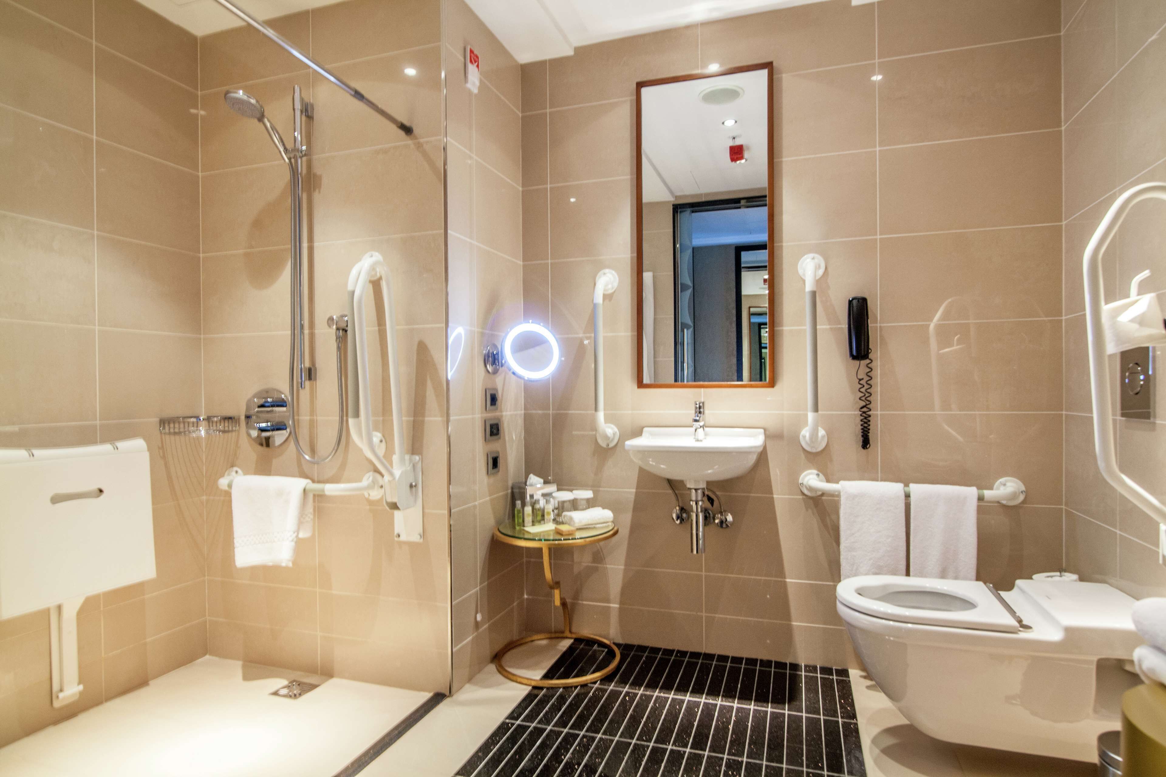 A modern bathroom with a shower, toilet, sink, and a glass-enclosed shower stall.