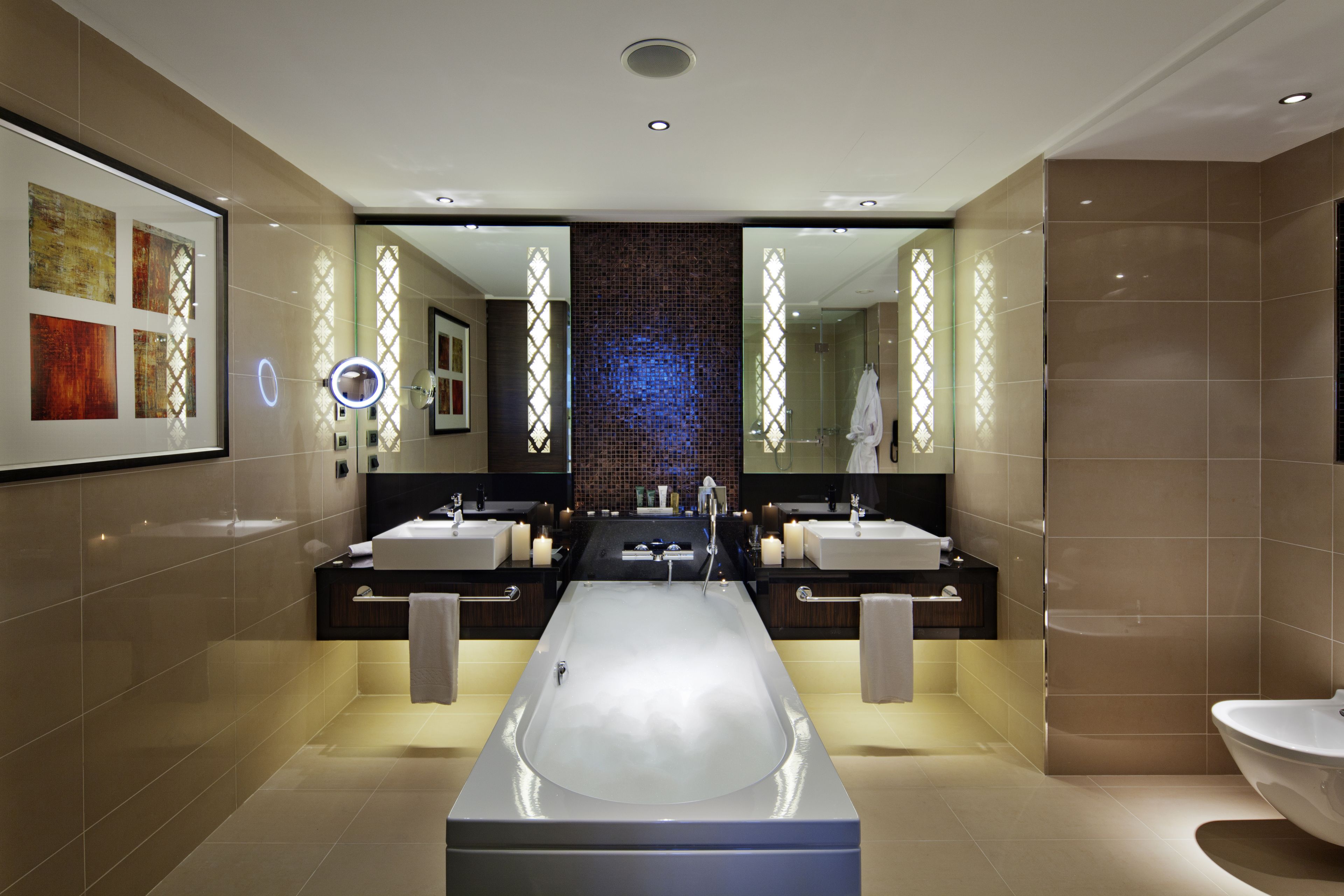 Un baño moderno con una bañera grande, dos lavamanos y un mueble de tocador.