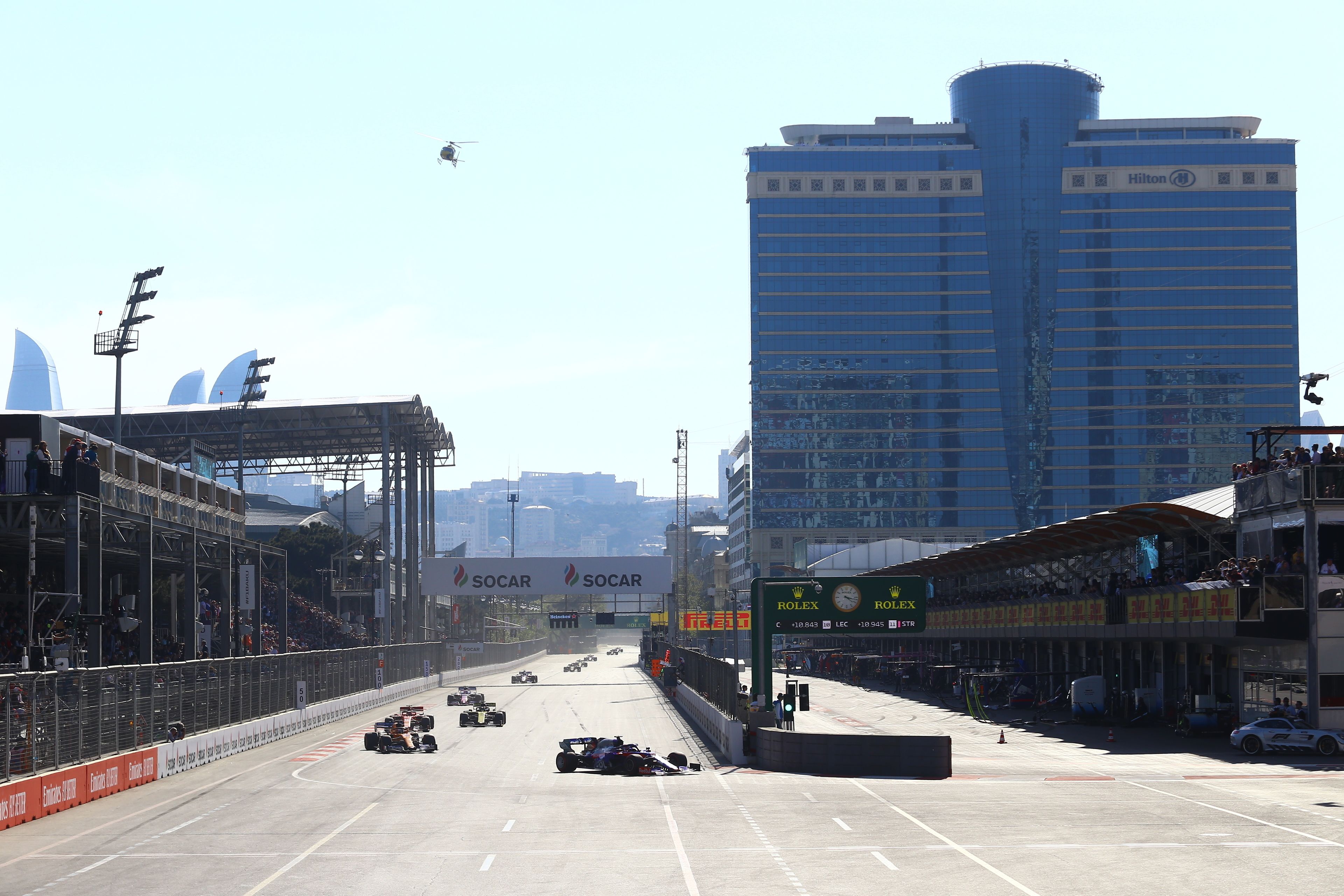 A hotel with a modern design, a large signboard, and a view of the city skyline.