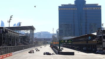 A hotel with a modern design, a large signboard, and a view of the city skyline.