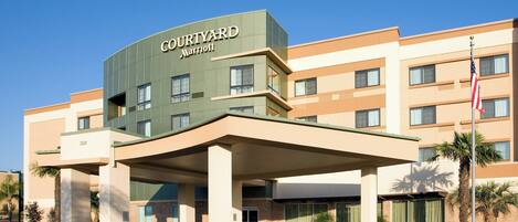 A Courtyard Marriott hotel with a modern design, featuring a covered entrance and multiple floors.