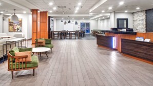 A modern hotel lobby with a reception desk, seating area, and a large window. - Fairfield Inn & Suites by Marriott Toronto Mississauga (Mississauga)