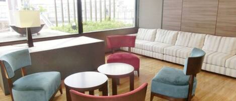 A modern lounge area with a sofa, chairs, and tables.