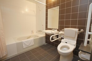 A modern bathroom with a bathtub, toilet, and sink.