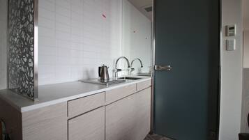 Un baño moderno con un espejo grande, un lavamanos y una puerta.
