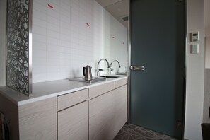 A modern bathroom with a large mirror, a sink, and a door.