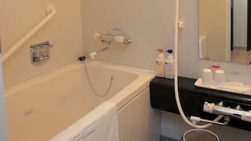 Un baño con bañera, ducha, lavabo con artículos de aseo y un perchero para toallas.