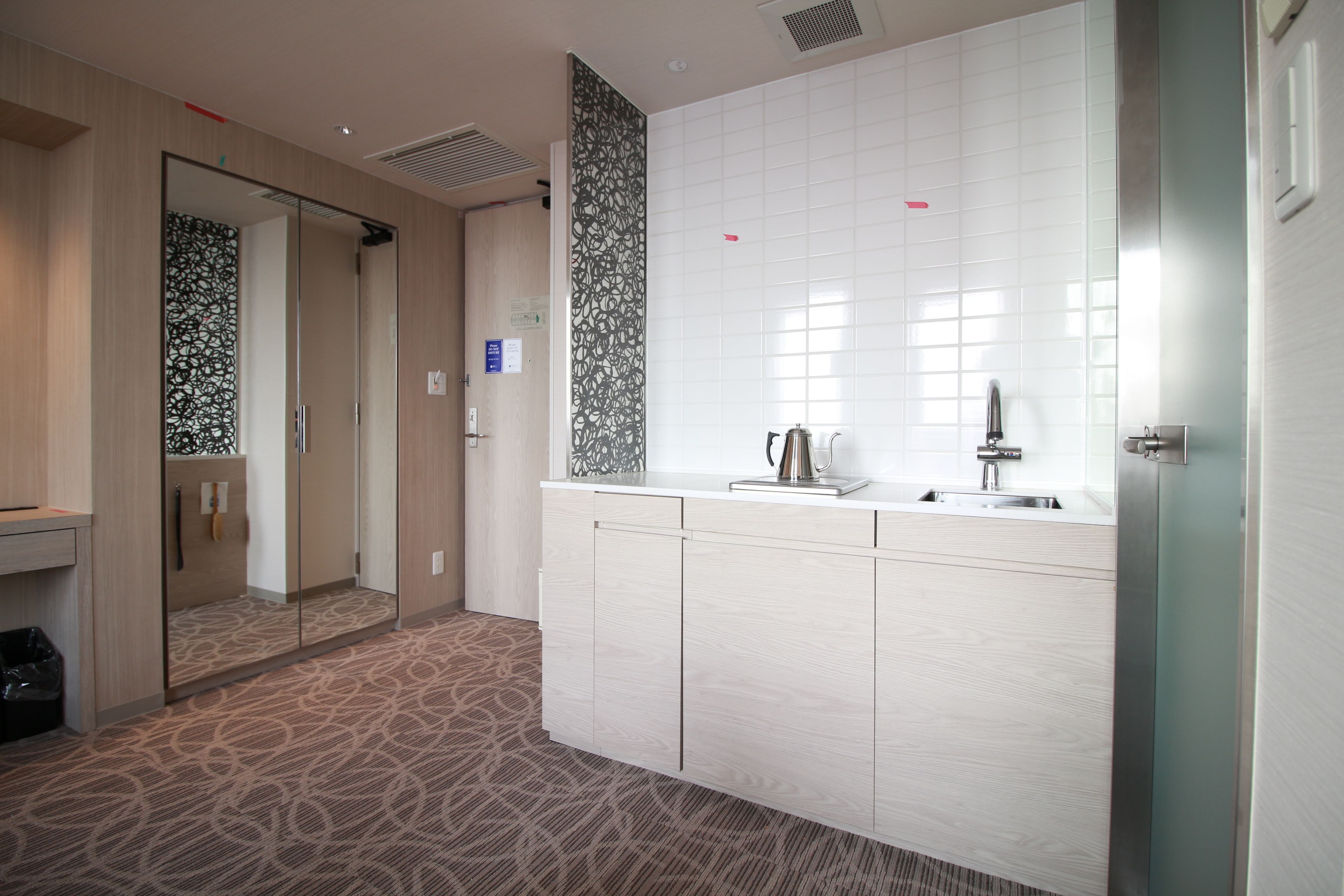 Een moderne hotelbadkamer met een grote spiegel, een wastafel en een toilet.