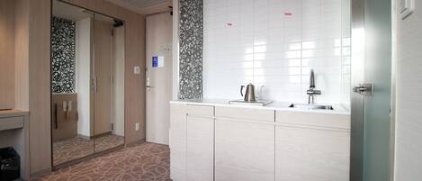 A modern hotel bathroom with a large mirror, a sink, and a toilet.
