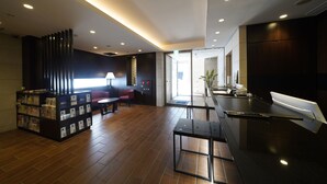 A modern lobby with a reception desk, seating area, and a counter with a menu. - Meitetsu Inn Nagoya Sakuradori (Nagoya)
