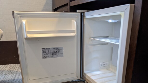 Un refrigerador abierto con una etiqueta en la puerta.