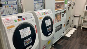 A row of front-loading washing machines with control panels and instructions. - Meitetsu Inn Nagoya Sakuradori (Nagoya)
