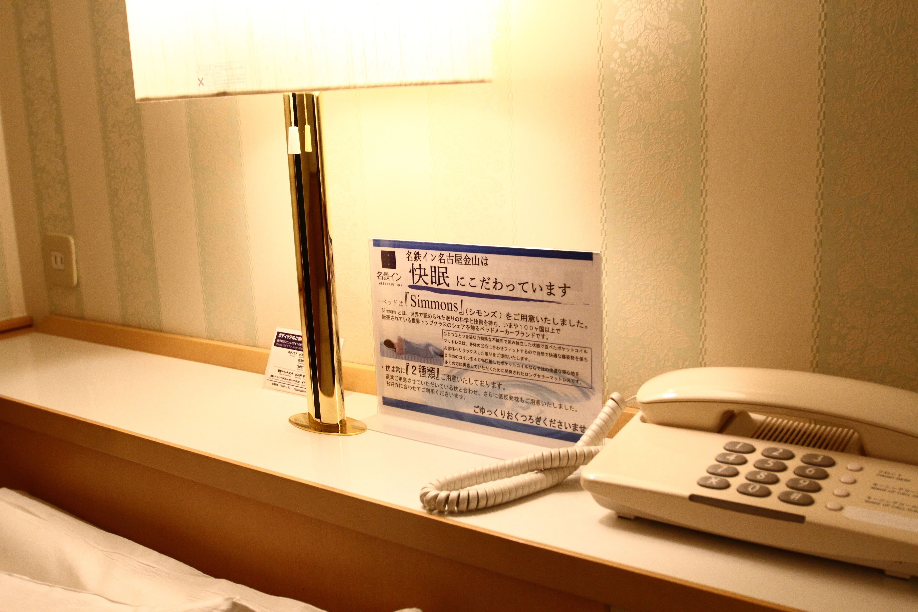 Et hotellets reception med en lampe, et skilt og en telefon.