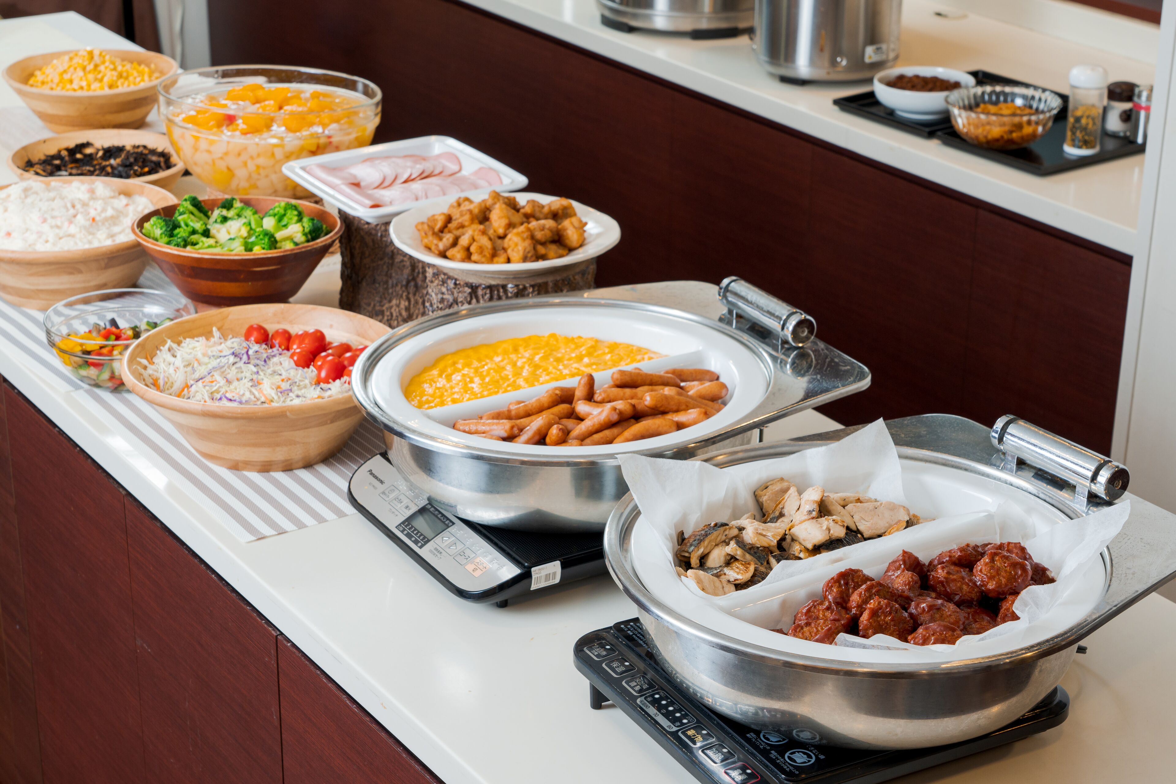 Mesa de buffet com diversos alimentos e uma balança.
