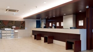 A reception area with a counter, seating, and a wall-mounted display.