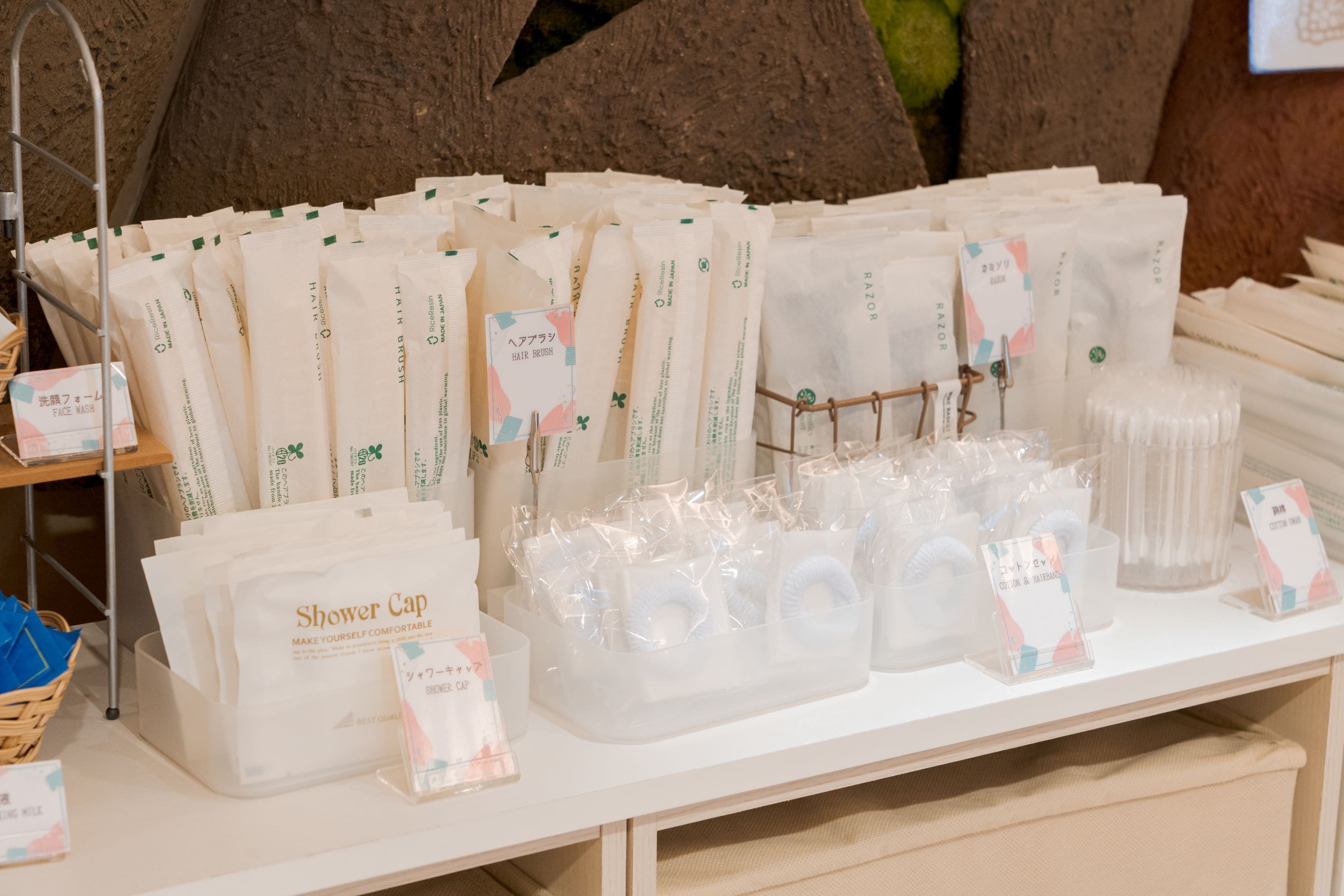 A display of various personal care products including face wash, hair brush, and shower cap.