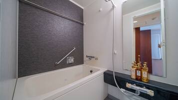 A modern bathroom with a bathtub, a shower, and a vanity with toiletries.