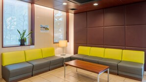 A modern waiting area with a sectional sofa, a small table, and a potted plant.