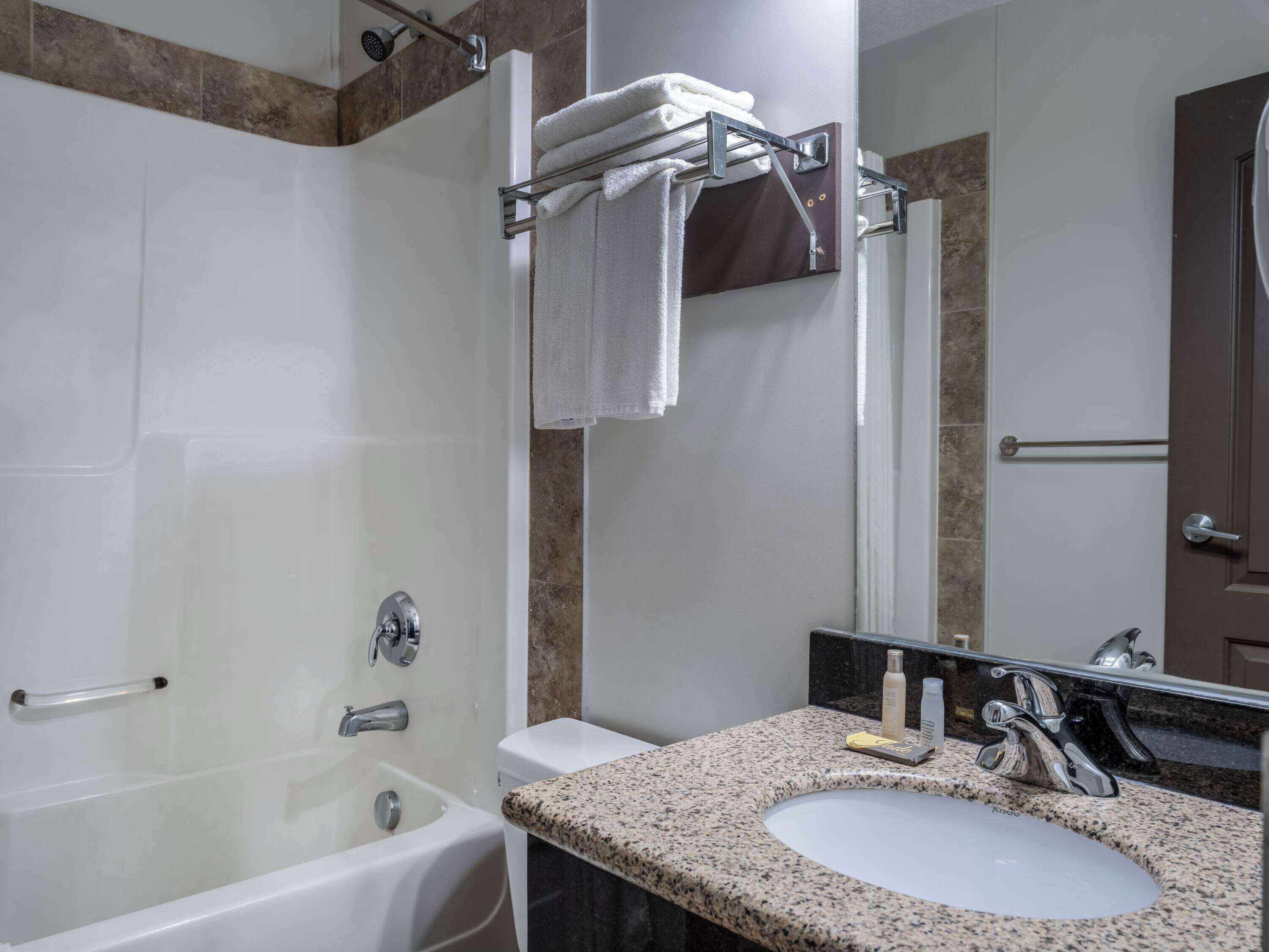 Un baño moderno con bañera, lavamanos y ducha.