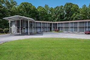 A motel with a covered entrance, multiple floors, and a parking lot.