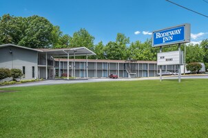 A motel with a signboard indicating 'Rodeway Inn' and 'New Rooms'.