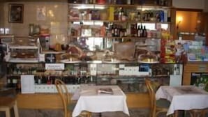 Un restaurante con barra, mesas y sillas.