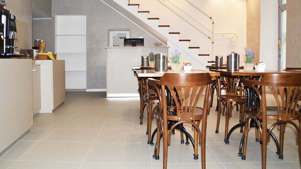Una cocina moderna con zona de comedor, que incluye una escalera, sillas de madera y una encimera de cocina.