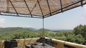 A dining area with a table set for four, overlooking a scenic landscape. - Domaine de Borie Chambres d'Hôtes (Bretenoux)