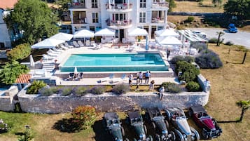 Una piscina al aire libre de temporada, sombrillas