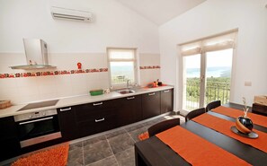 A modern kitchen with a Bosch oven, a window with a view, and a balcony with a railing.
