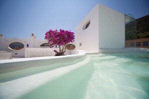 Una piscina al aire libre, sillones reclinables de piscina