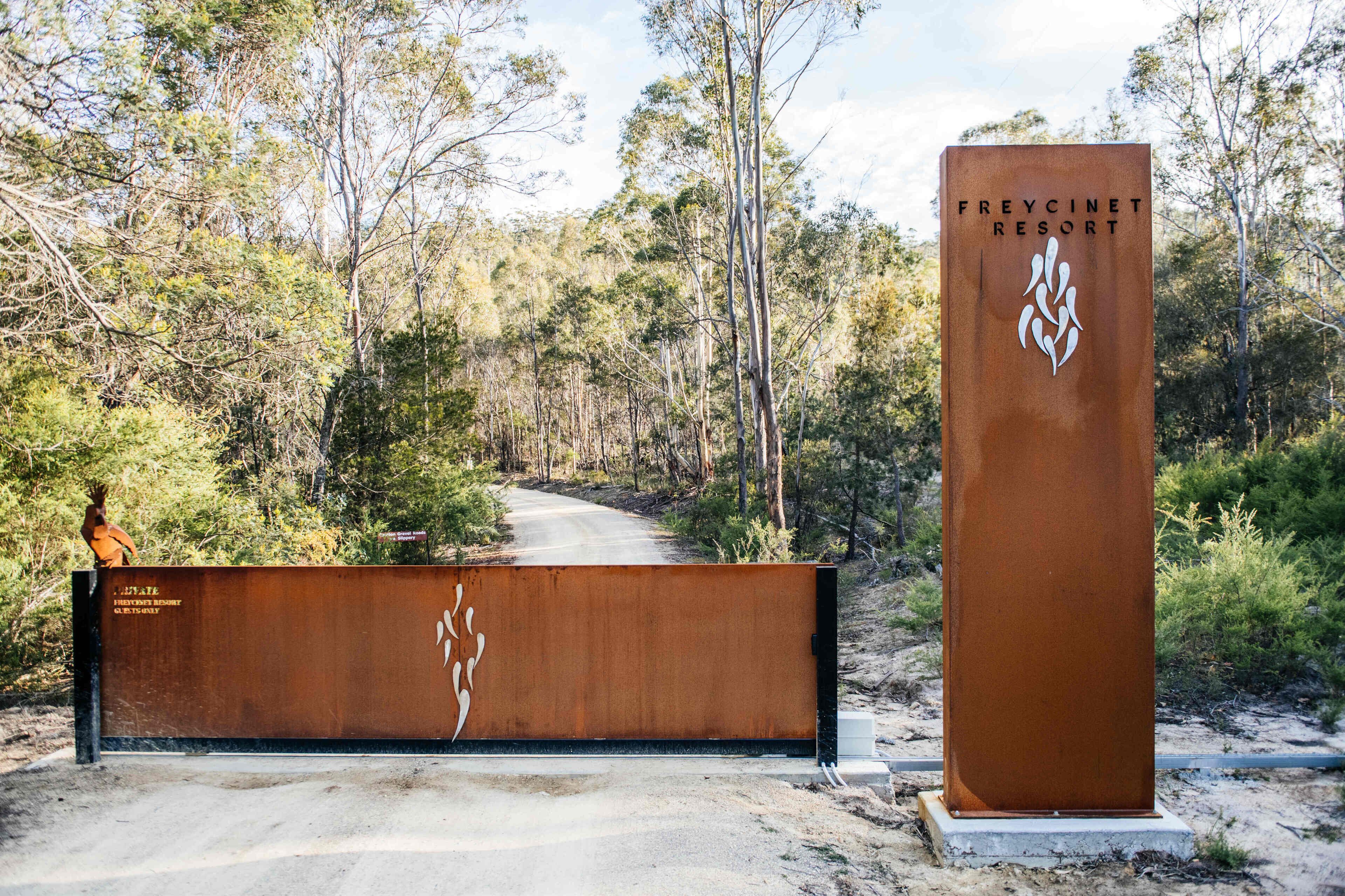 A sign for Freycinet Resort with a natural landscape in the background.