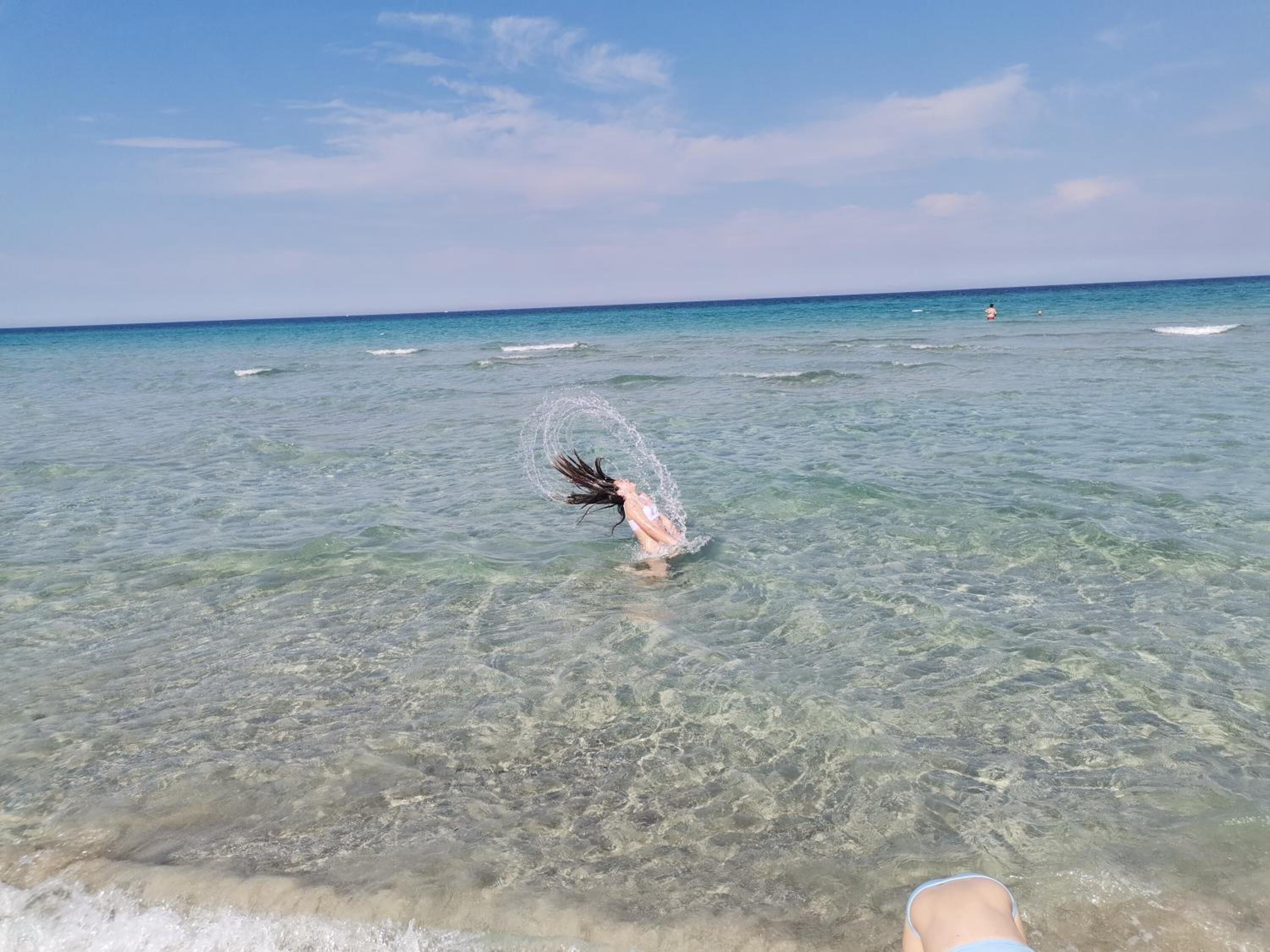 A clear view of the ocean with a person in the water.