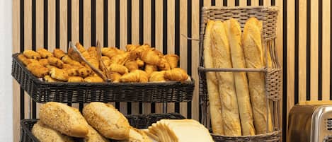 Un bufé con cestas de pan y pasteles.
