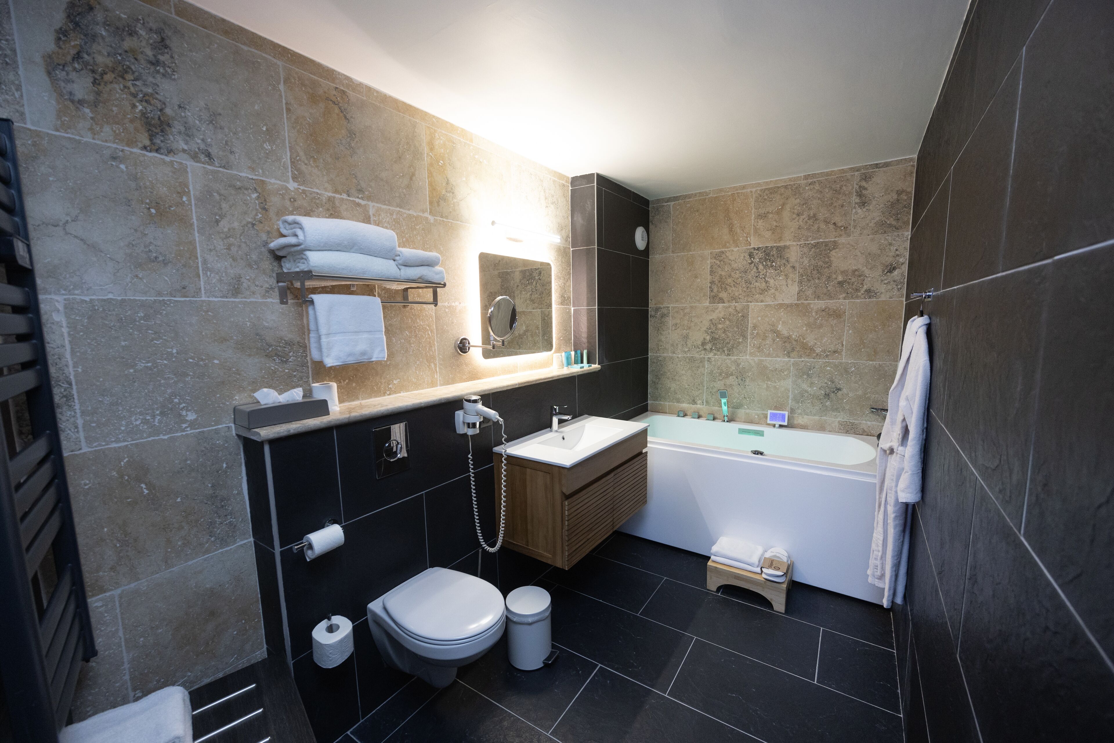 A modern bathroom with a toilet, sink, and bathtub.