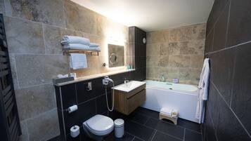 A modern bathroom with a toilet, sink, and bathtub.