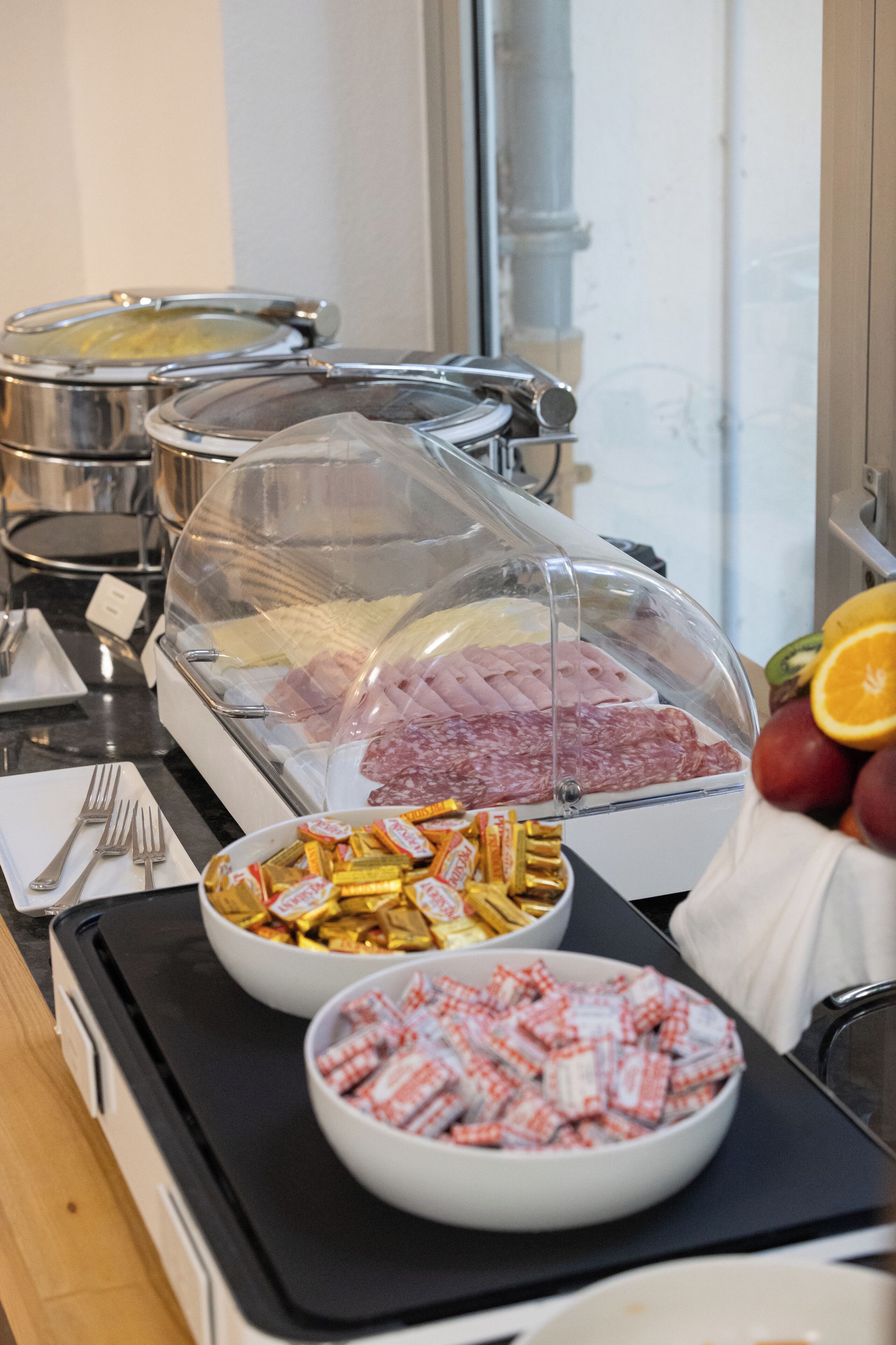 Un buffet proposant une variété de plats, notamment des viandes, des fromages et des amuse-gueules.