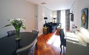 Cozy living room with a dark wood floor, black dining table, and comfortable sofa.