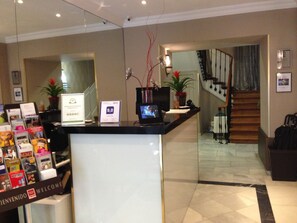 Welcome to our reception area, where friendly staff are available to assist with your stay. A computer and phone are conveniently located at the desk, along with helpful signs and a warm welcome.