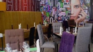 A restaurant interior with a modern design, featuring a large abstract art piece on the wall and a visible menu board. - Hotel El Conquistador (Cuenca)