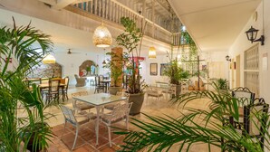 Un vaste espace intérieur doté d’un haut plafond, de nombreux coins salon et d’une abondance de verdure.