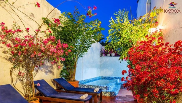 A spa area with sun loungers, a mosaic pool, and lush greenery. - Hotel Kartaxa Cartagena (Cartagena)