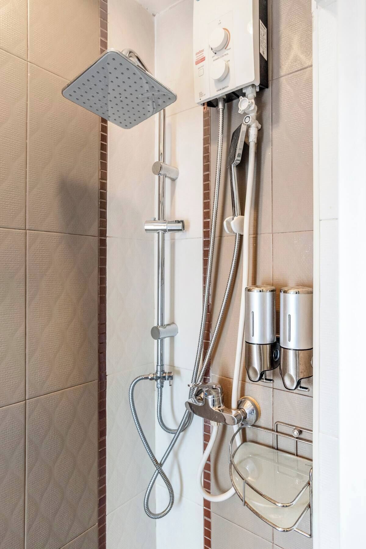 A shower with a handheld showerhead, a wall-mounted control panel, and a glass-enclosed sink with a chrome faucet.
