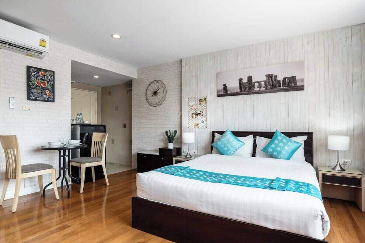 A hotel room with a bed, a desk, and a chair.